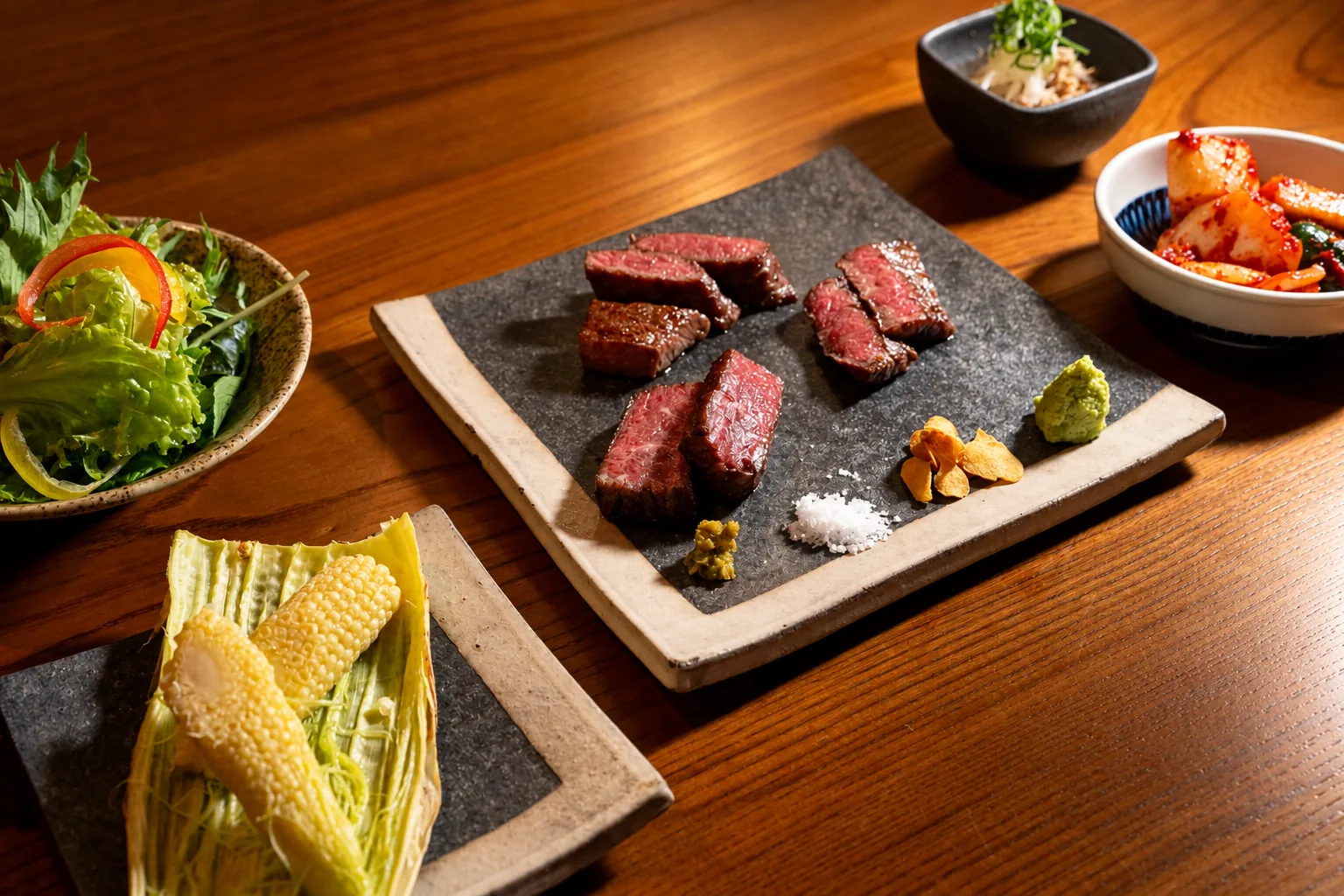 ステーキを中心に野菜や小鉢を添えたコース料理