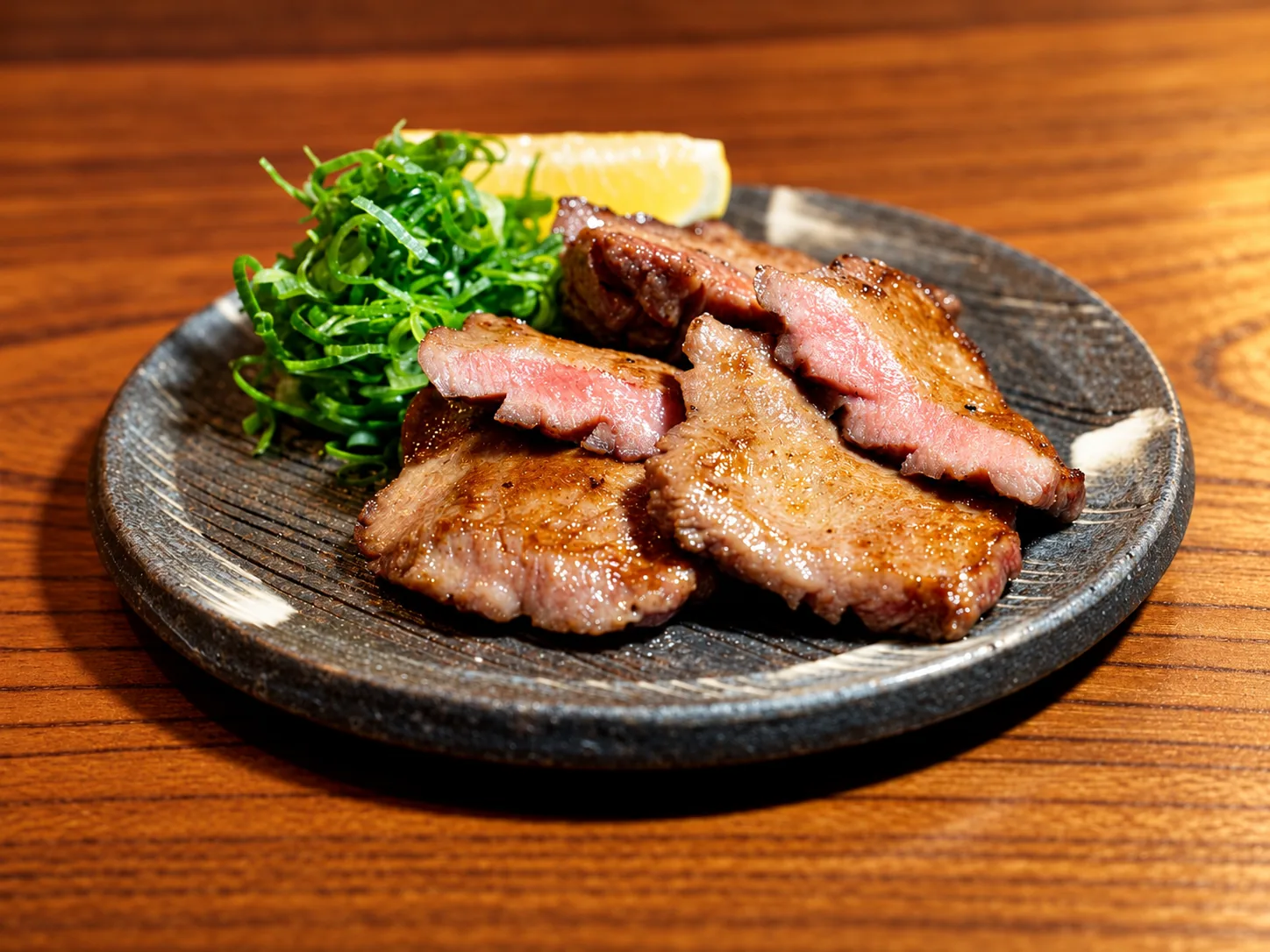 焼き上げた厚切り牛タンにねぎとレモンを添えた一皿