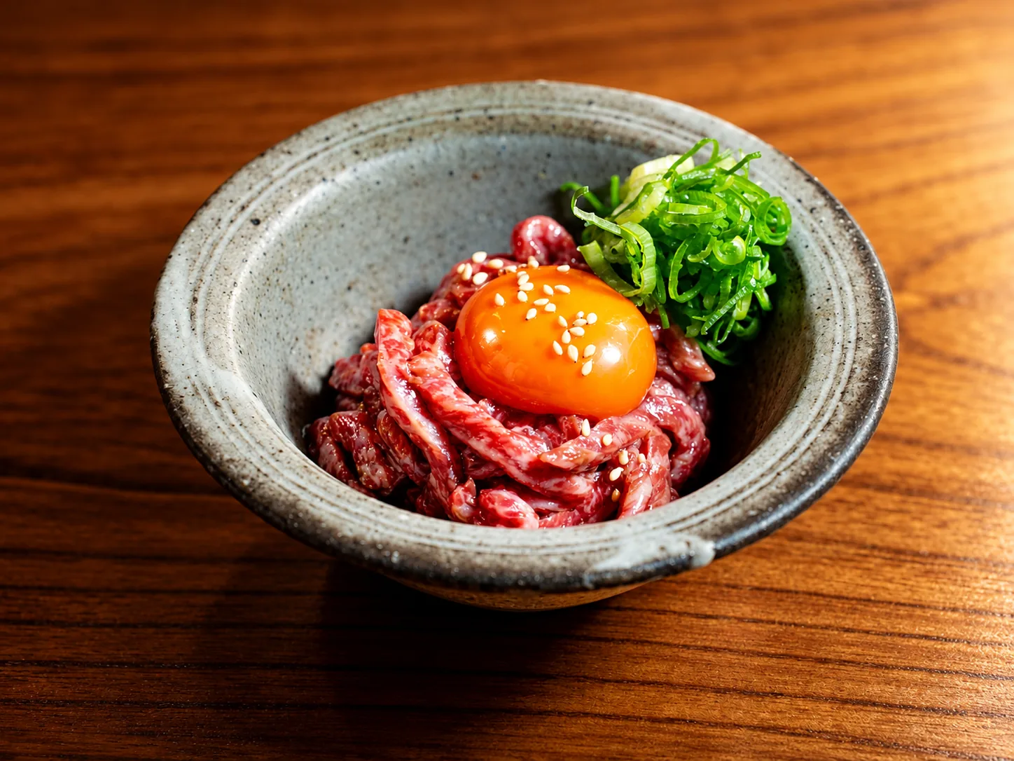 卵黄をのせてねぎを添えたユッケ